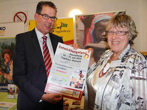 Dr. Gerd Müller,  Bundesminister für Entwicklungszusammenarbeit mit Margret Kopp und dem Plakat zur Ausstellung „Entwicklungsland-D“
