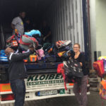 Die Schultaschen finden ihren Platz im Container - da macht das Beladen richtig viel spaß.