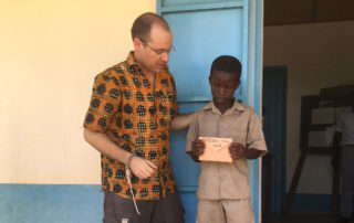 Andy Kopp trifft eines der Patenkinder in Kouma Apoti, Togo, Afrika