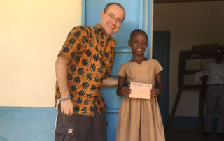 Andy Kopp trifft eines der Patenkinder in Kouma Apoti, Togo, Afrika