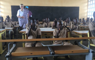 Die Kinder in Fobenga sitzen an den neuen Schulmöbeln aus Tauberbischofsheim