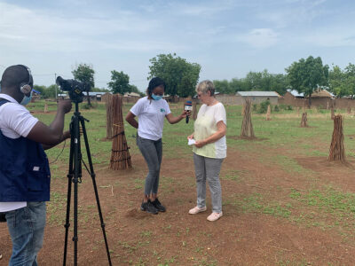 Margret Kopp wird vom togoischen Fernsehen auf einem Feld zu unserer Baumpflanzung interviewd.