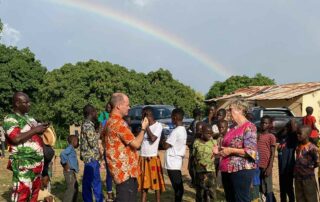 Margret und Andy Kopp berichten live aus Togo, während ein Regenbogen über ihnen erscheint