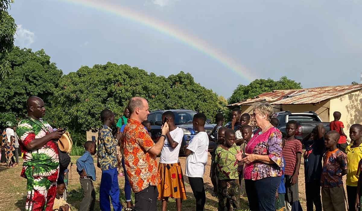 Margret und Andy Kopp berichten live aus Togo, während ein Regenbogen über ihnen erscheint