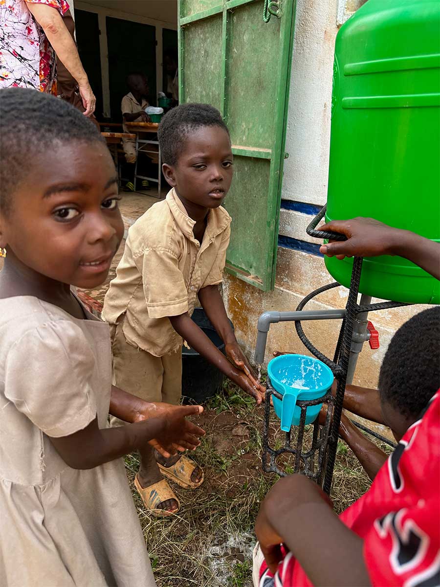 Kinder waschen sich vor der Schulkantine die Hände