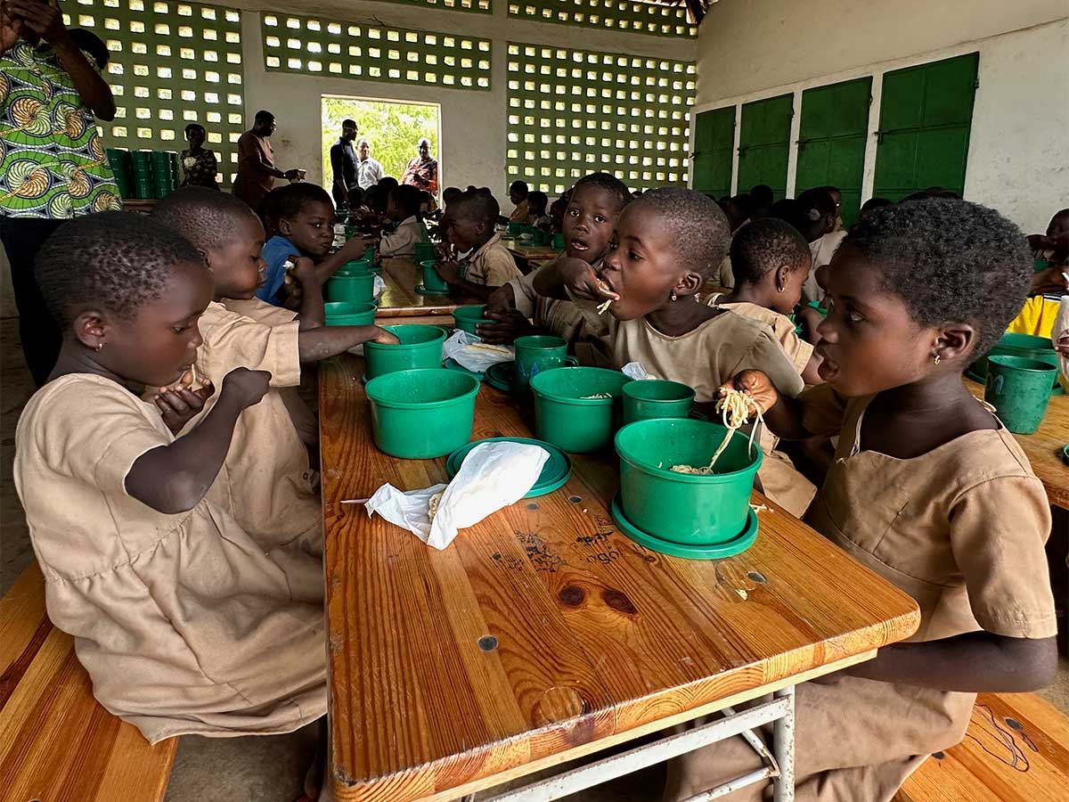 Kinder essen mit den Händen in der Schulkantine
