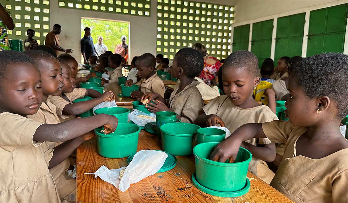 Die Schulkinder essen mit den Händen.