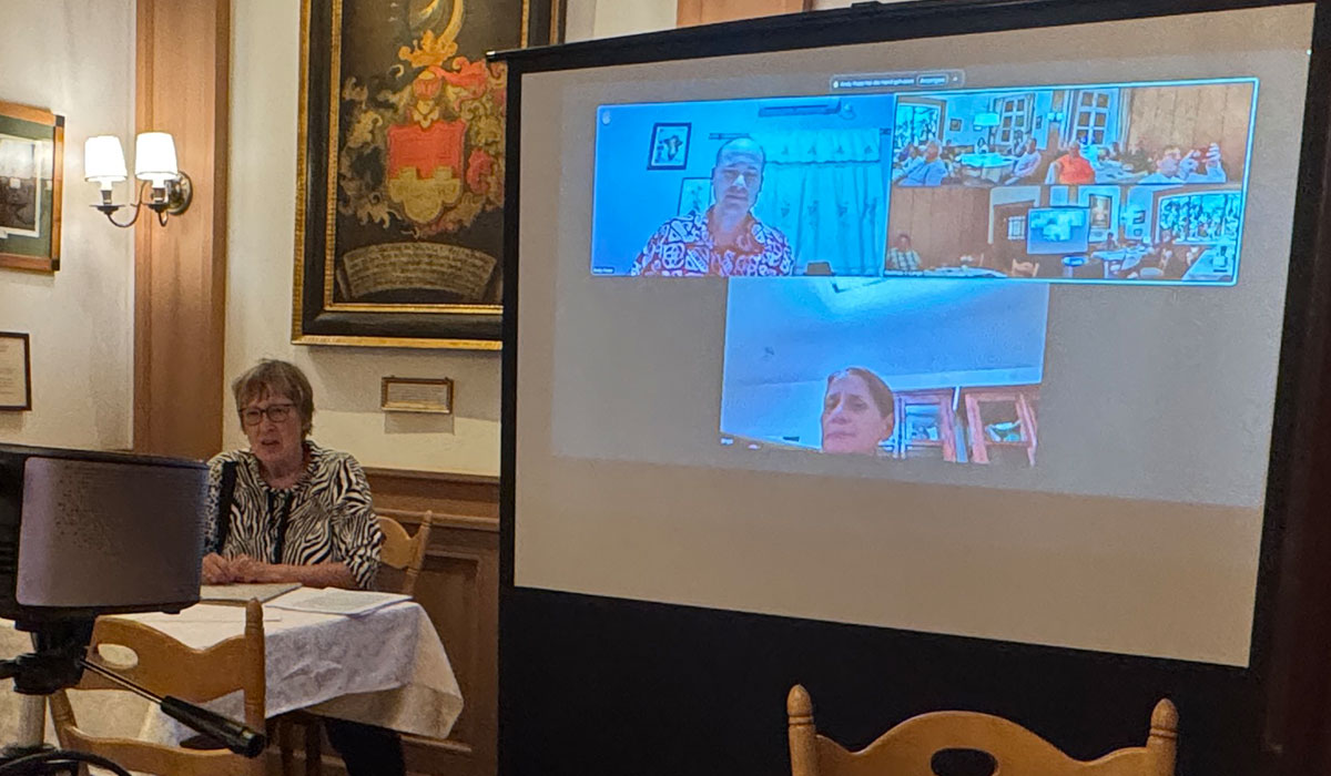 Margret Kopp bei der Mitgliederversammlung und die auf Leinwand dazu geschalteten Birgit Birnstiel und Andy Kop