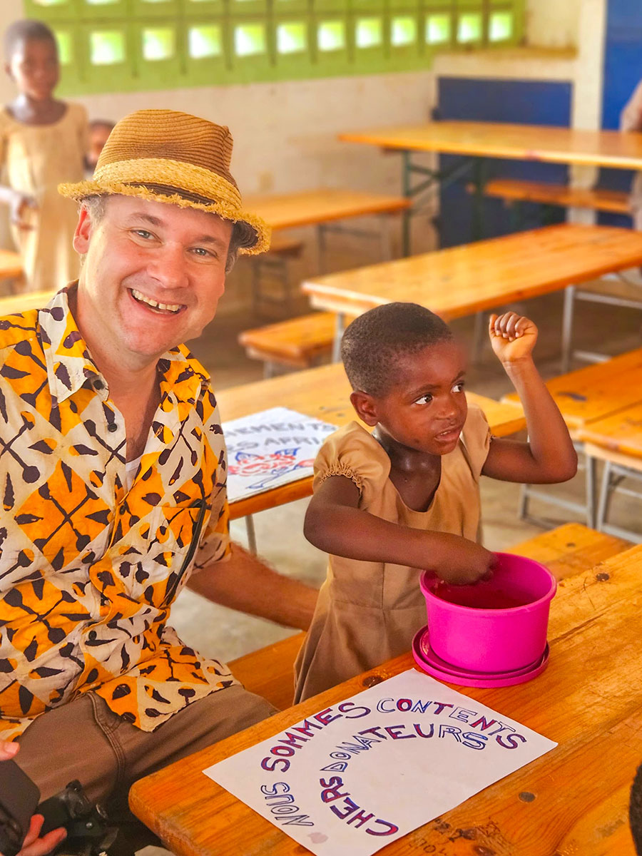 Andy Kopp mit einem Schulkind bei der Kinder-Schulspeisung