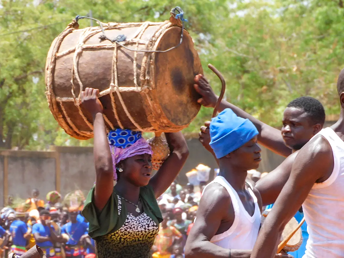 Frau trägt eine Trommel auf dem Kopf