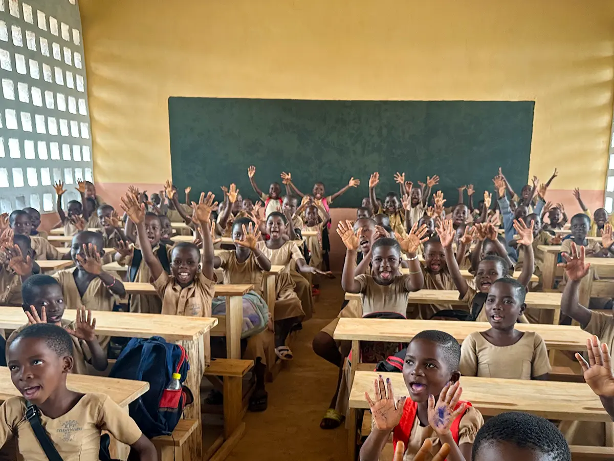 Winkende Kinder in einer Schulklasse